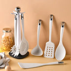 7-Piece Silicone Kitchen Utensils Set with 360° Rotating Countertop Holder – White silicone heads and handles with silver-tone stainless steel hanging hooks/end caps. Heat-Resistant, Dishwasher Safe